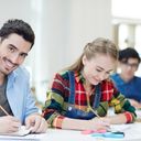 Boy and girl sitting in class taking notes