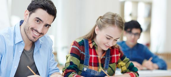 Boy and girl sitting in class taking notes