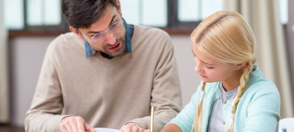 Private tutor helping girl with homework