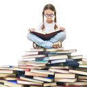 Little girl sitting on a mountain of books