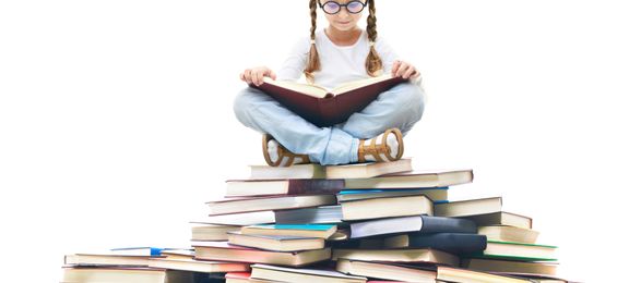 Little girl sitting on a mountain of books