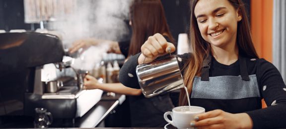 Ung barista som serverer kaffe