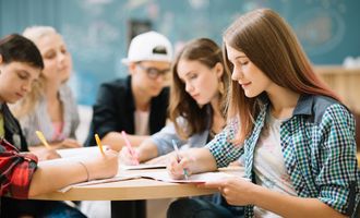 Gjeng med studenter som gjør lekser i timen