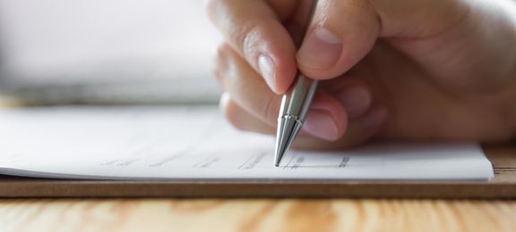 Hand and pencil writing on an exam